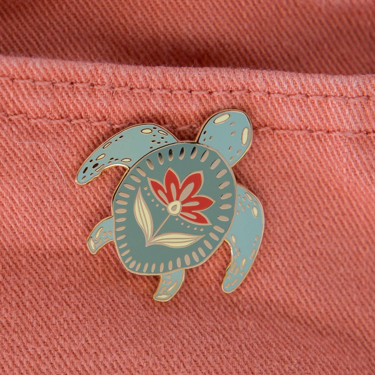Ocean enamel turtle pin with a teal shell and floral design