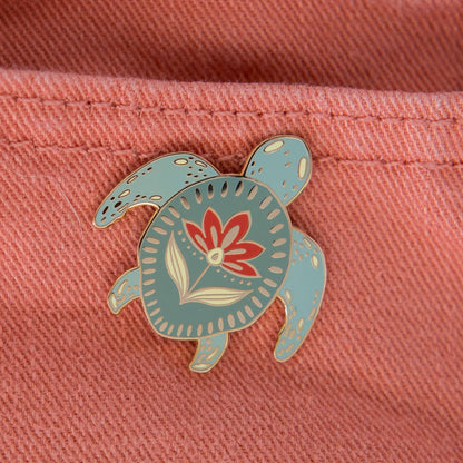 Ocean enamel turtle pin with a teal shell and floral design