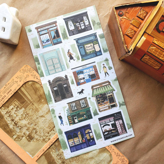 Sticker sheet featuring illustrated town buildings, storefronts, and character figures