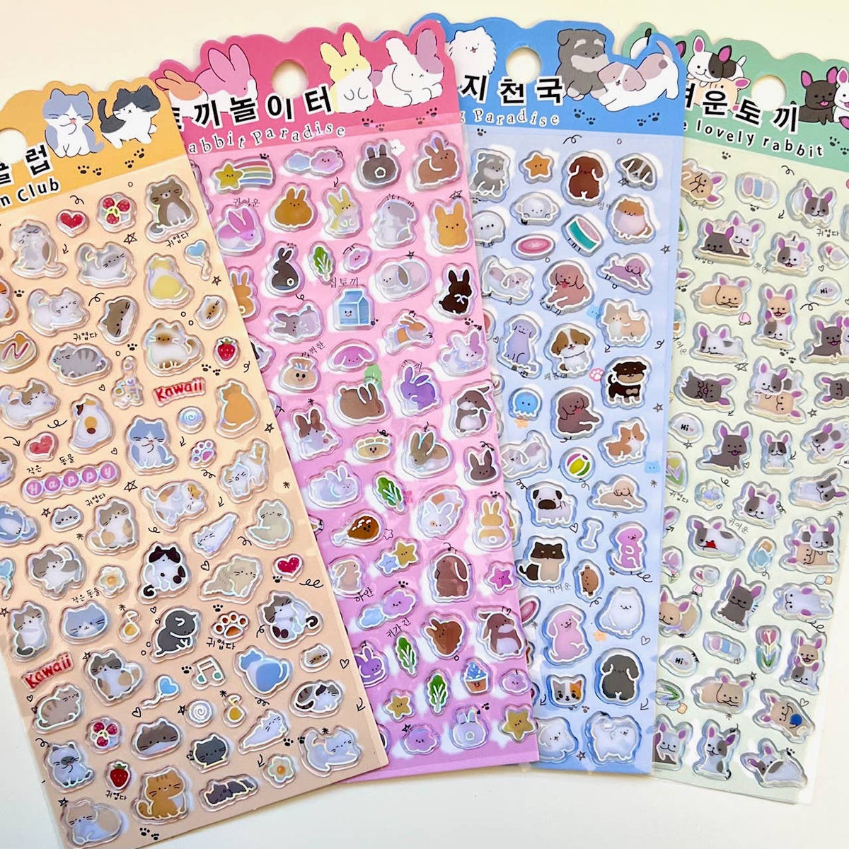 Four pastel sticker sheets with cartoon animals, badges, hearts, and outlined charms.