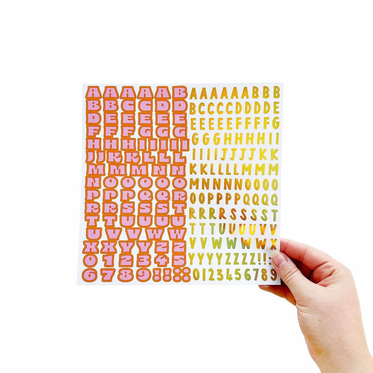 Orange letter and number sticker sheet held by a hand
