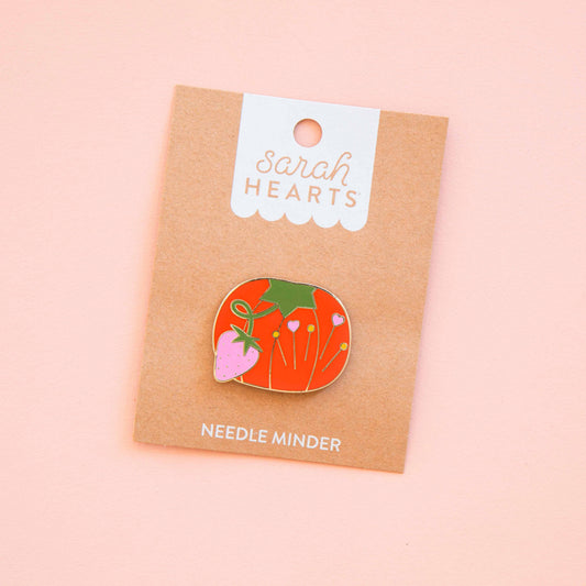 Tomato-shaped magnetic needle minder with colorful carrots and heart details