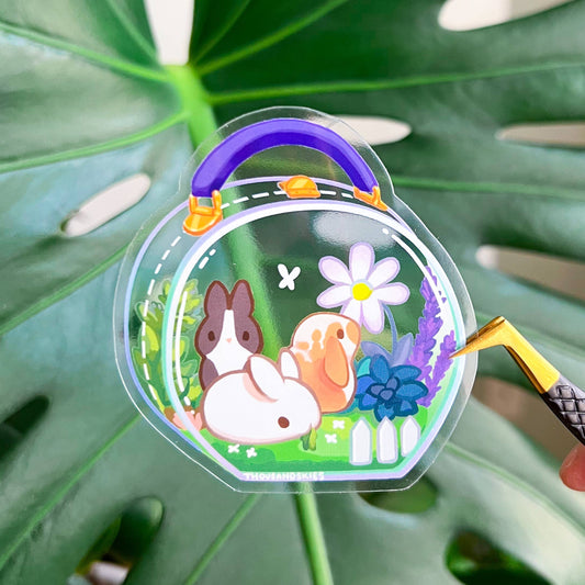 Transparent vinyl sticker in a bunny meadow pouch shape with purple flowers and handle