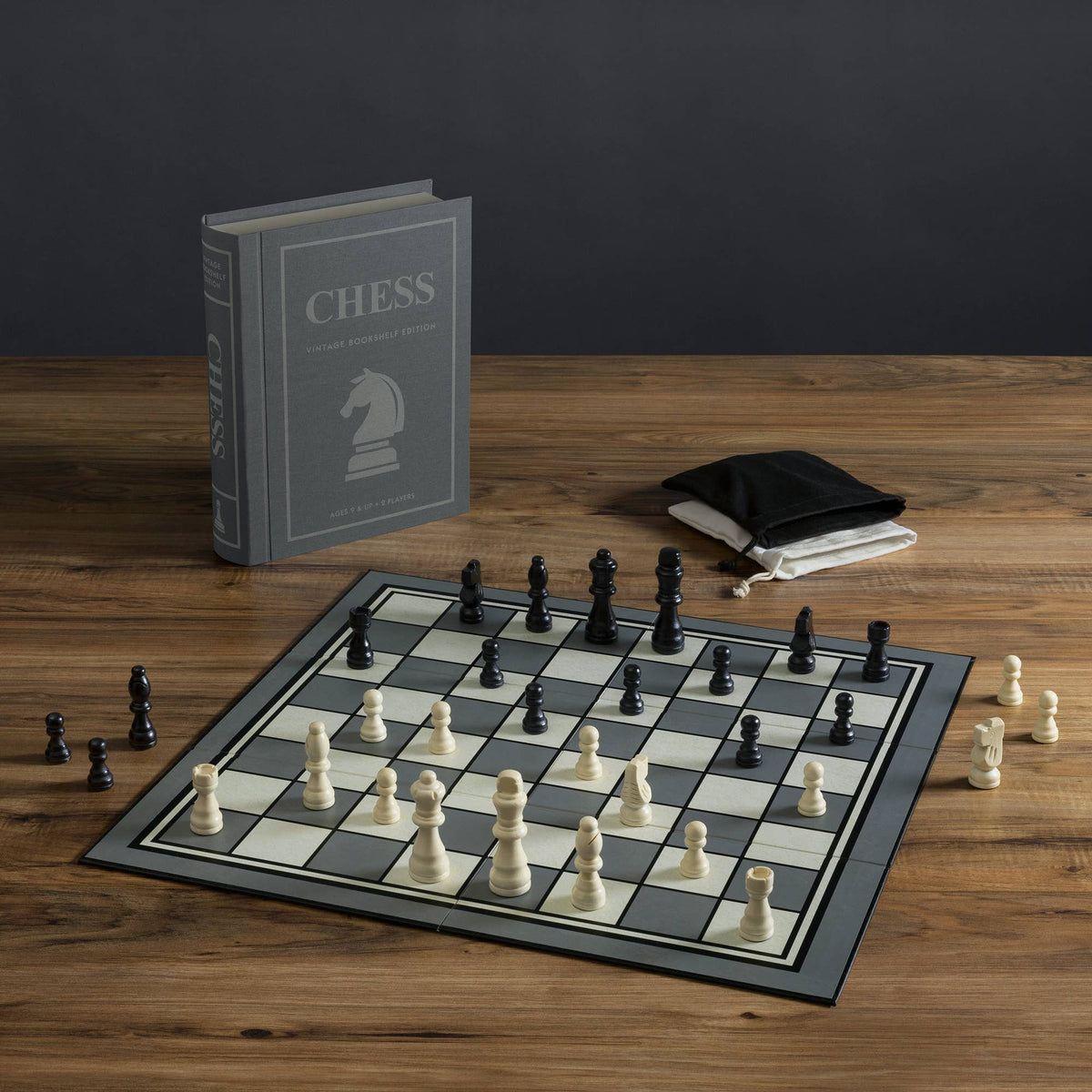 Chess set with checkered board, black pieces, and gray vintage CHESS bookshelf edition box