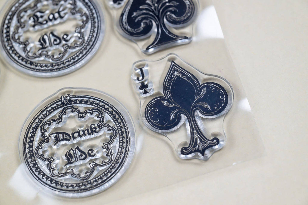 Close-up of clear stamps with ornate medallions, clock and fleur-de-lis spade shapes