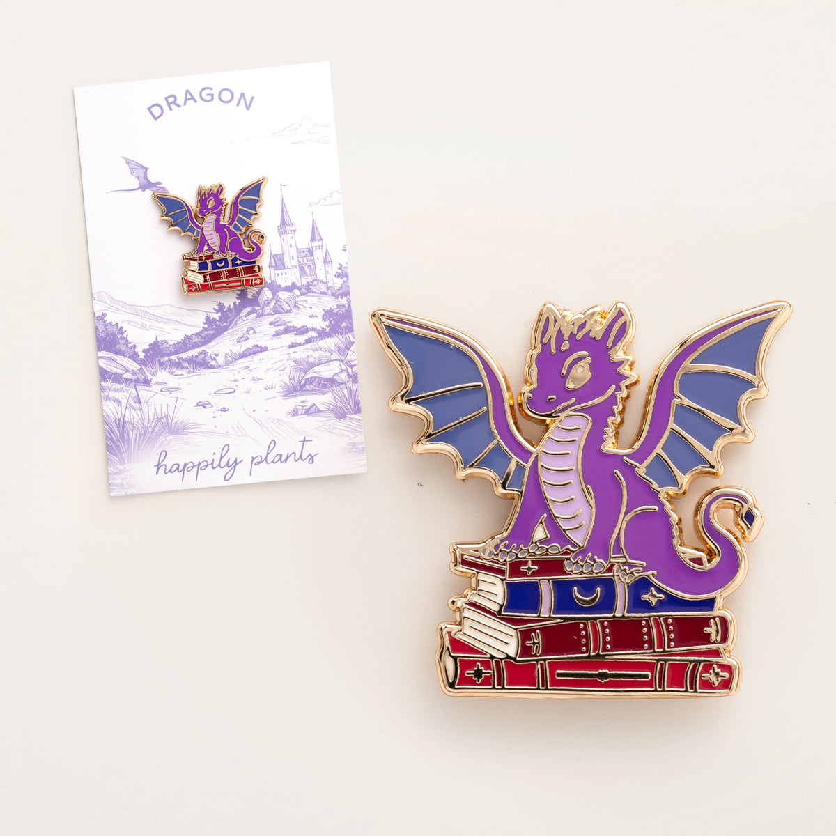 Dragon book pin beside fantasy postcard insert featuring purple dragon artwork
