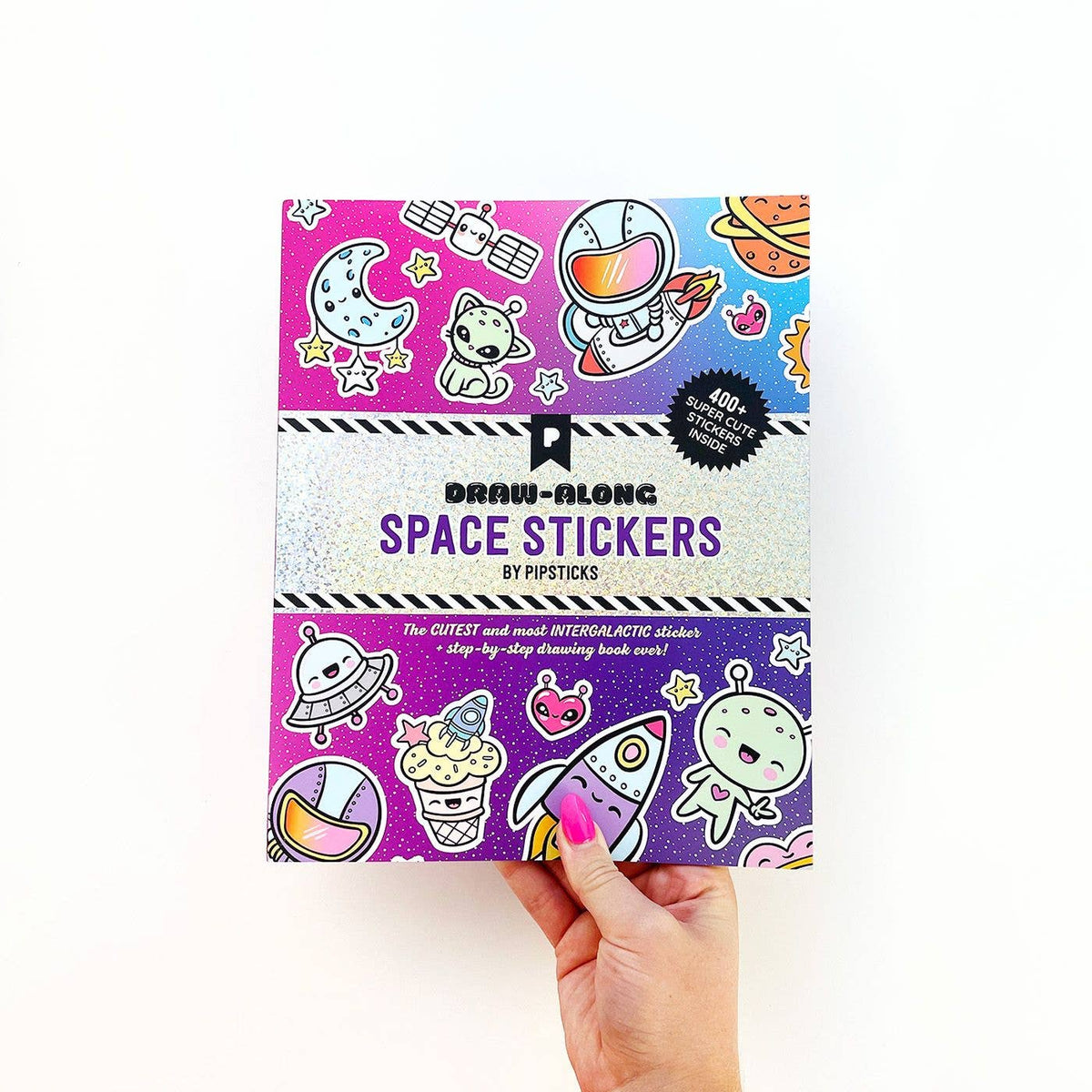 Space sticker book cover held in hand, showing aliens, stars, and astronaut illustration