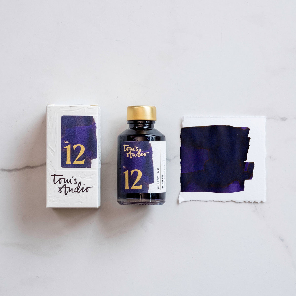 Fountain pen ink bottle with dark blue-purple ink swatch