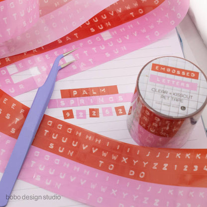 Embossed letter PET tapes in pink and orange with clear backing and roll