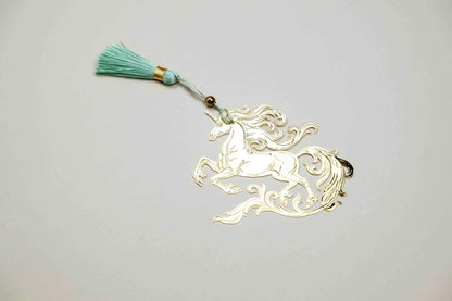 Light gold-tone unicorn bookmark with teal tassel cord and bead