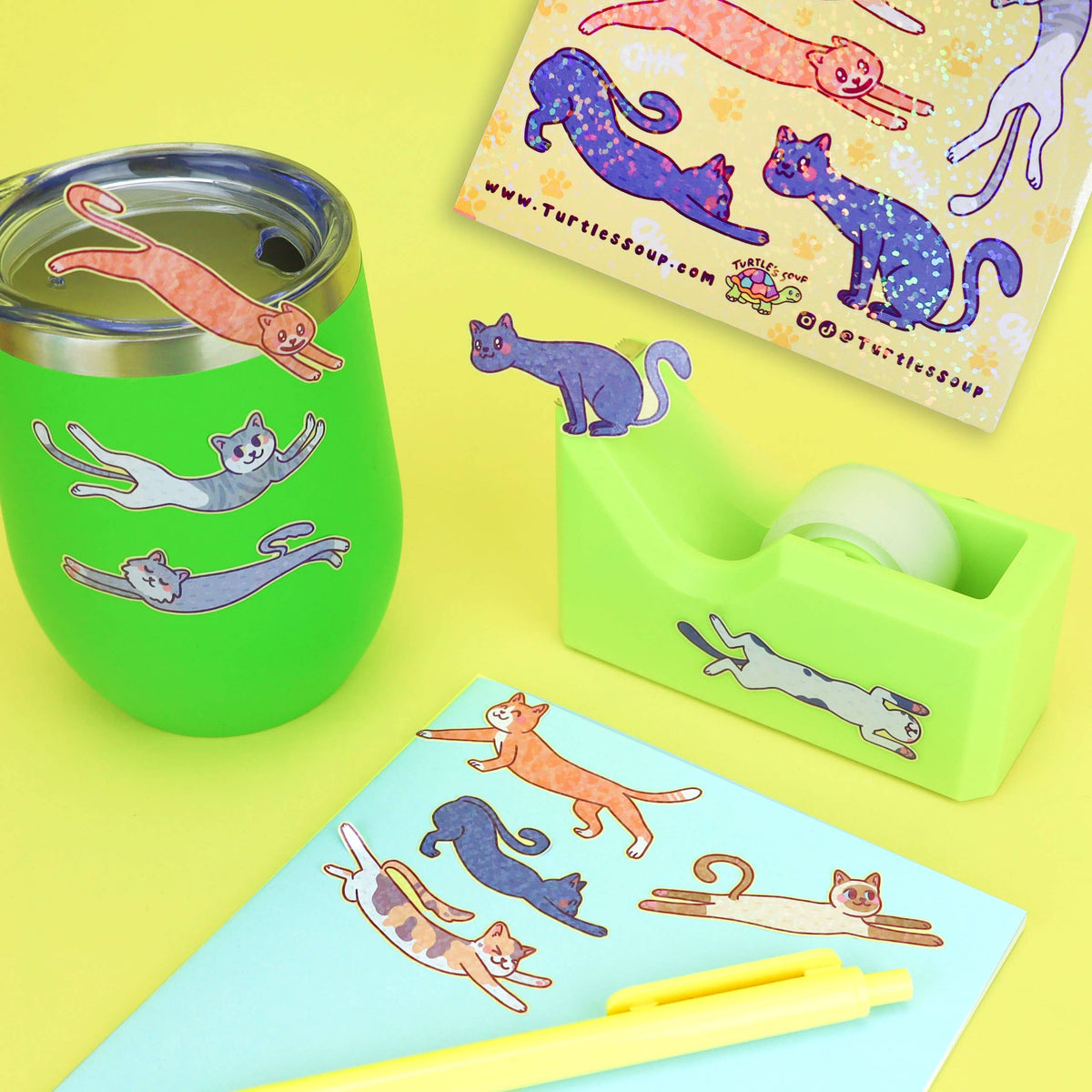 Cat sticker sheet with long cats in purple and orange, shown on a tabletop