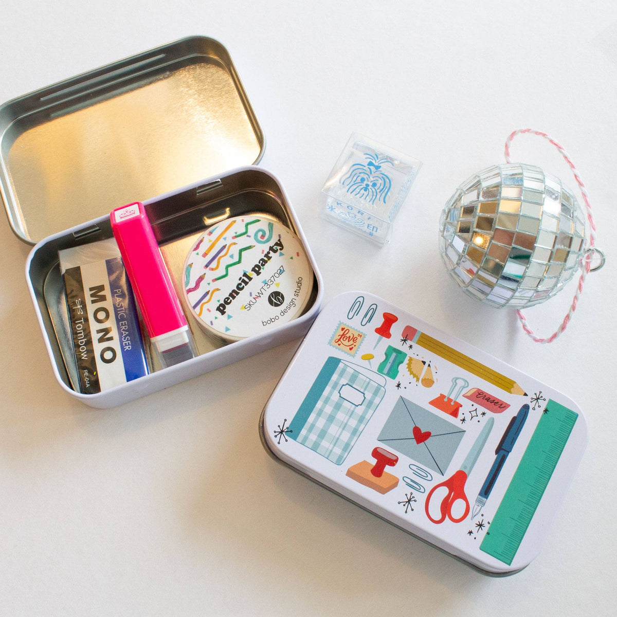 Stationery trinket tin organizer with open lid, mini cards, and colorful pens