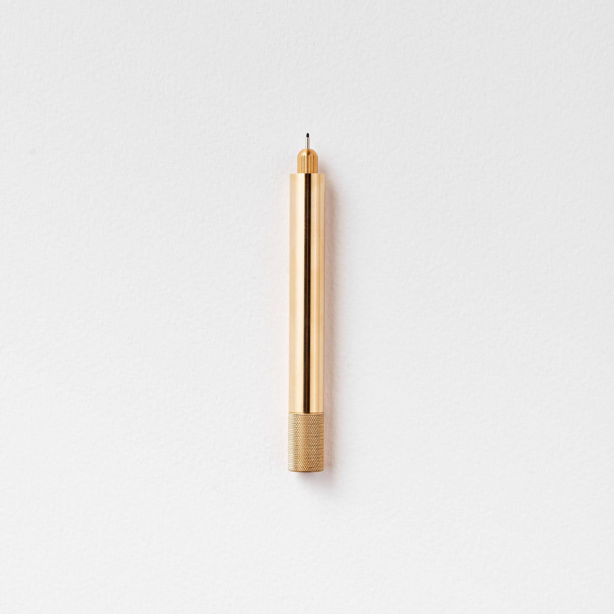 Brass metal pen with pointed nib and ribbed base grip