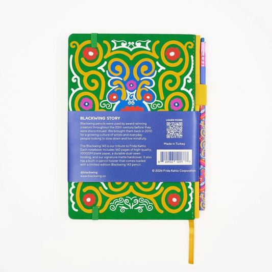 Green patterned notebook back with yellow ribbon bookmark and colored pencils