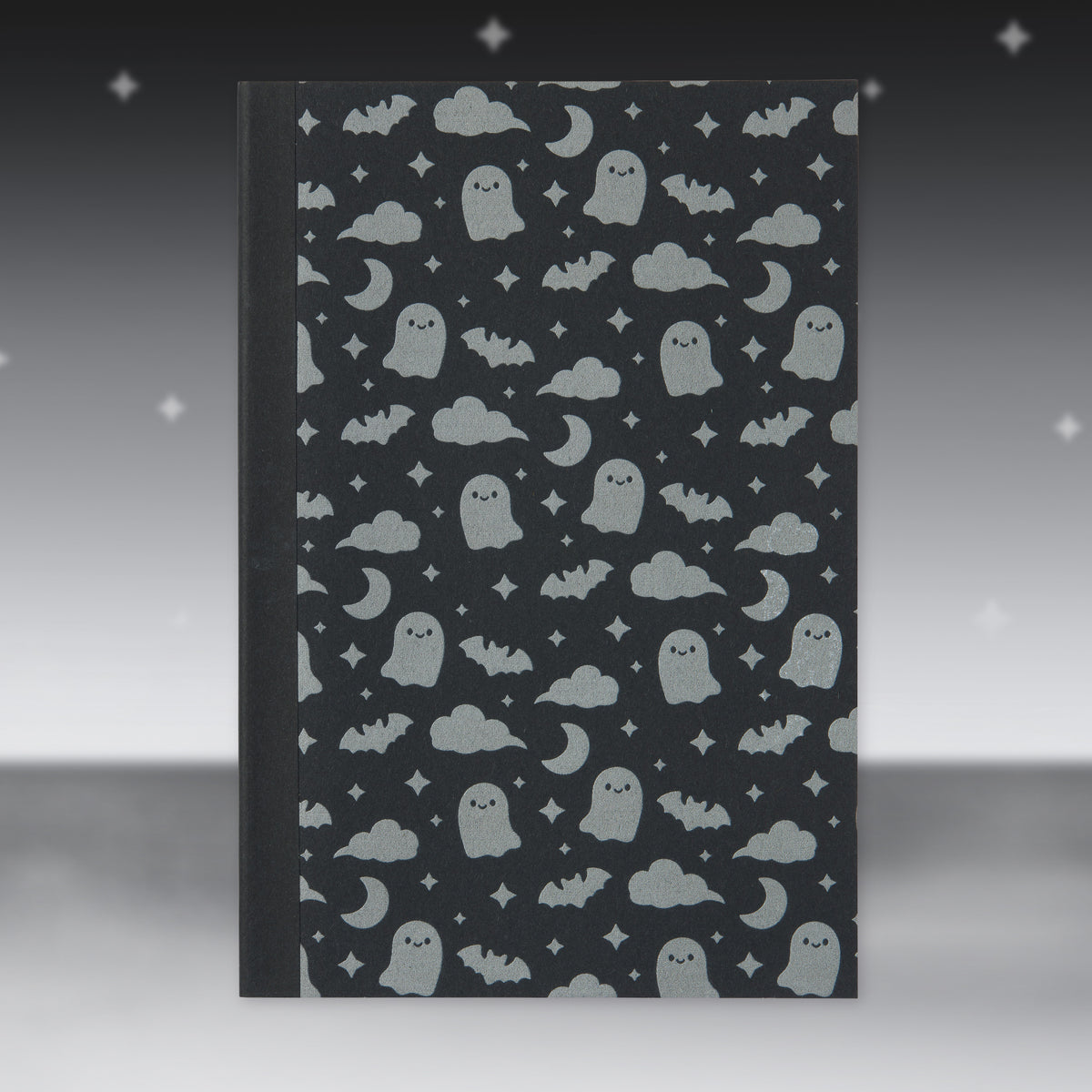 Black Halloween patterned paper sheet with ghosts, bats, and moons