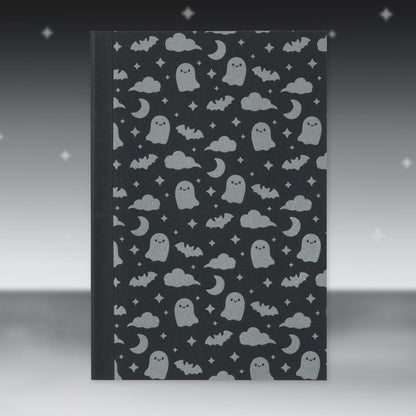 Black Halloween patterned paper sheet with ghosts, bats, and moons
