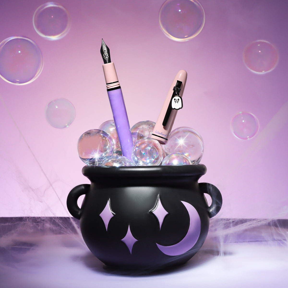 Pastel purple and beige decorative fountain pens in a black cauldron container