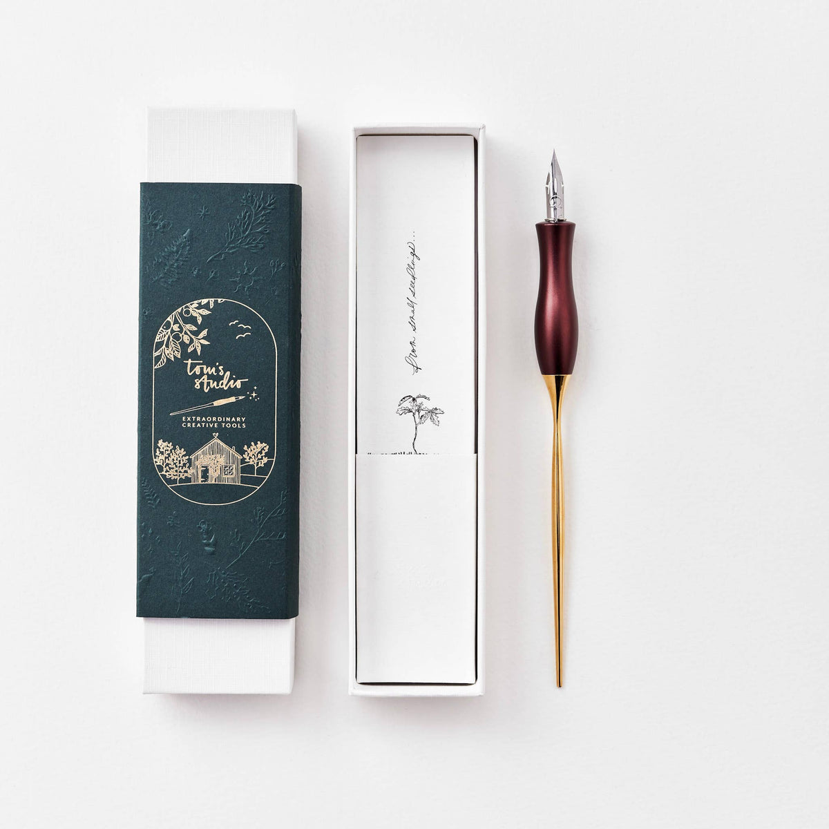 Burgundy calligraphy pen with oblique nib and gold accents, shown with gift box