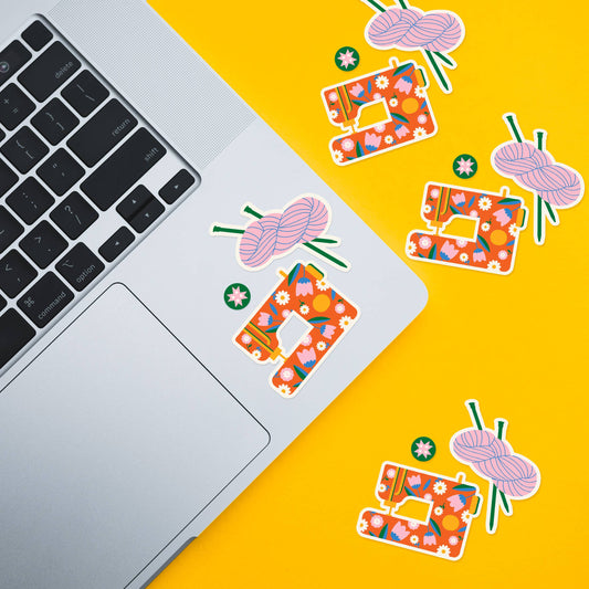 Sticker sheet designs on notebooks: yarn balls, sewing icons, quilt squares on yellow