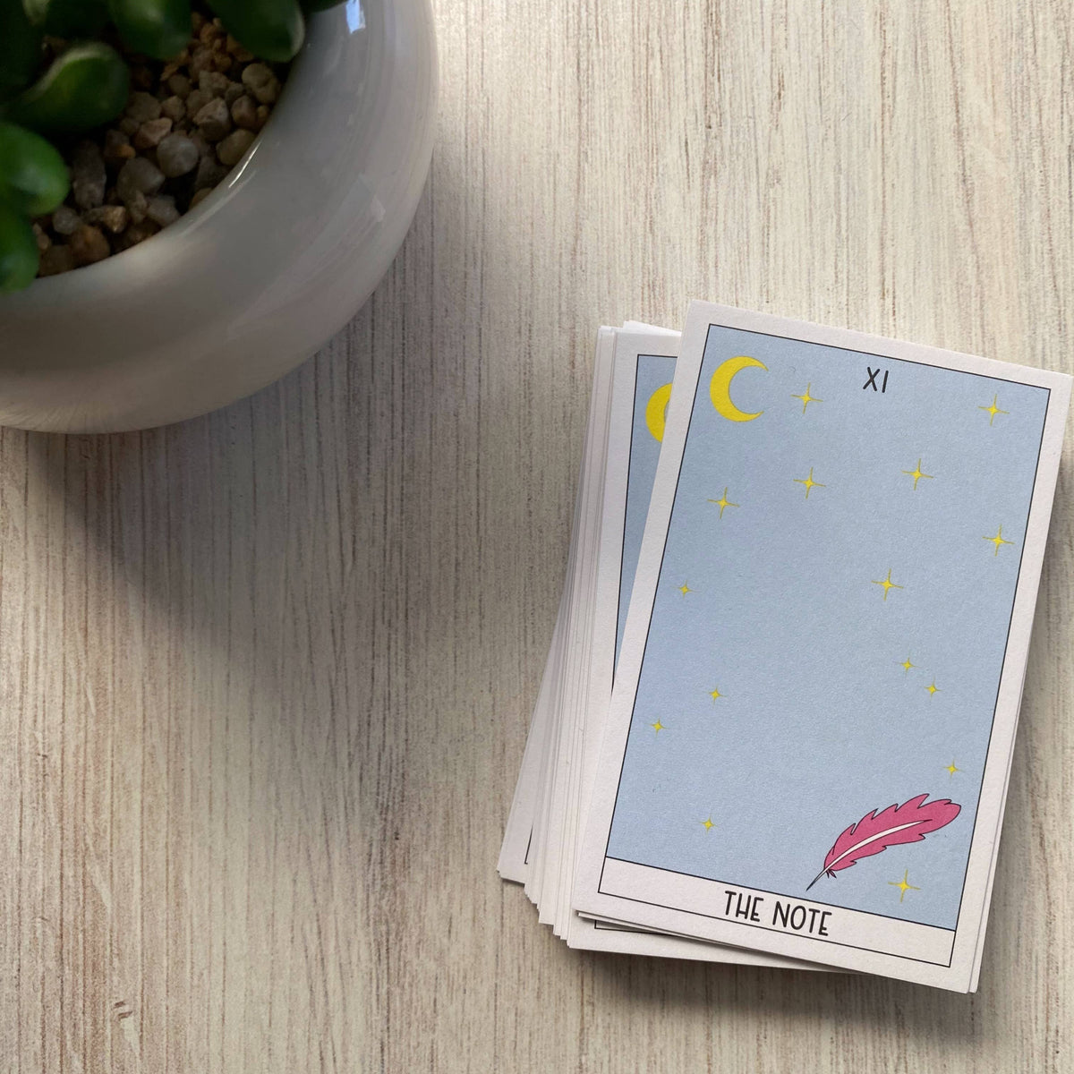 Tarot card mini notecards stacked, featuring a blue-gray moon, stars and feather design.