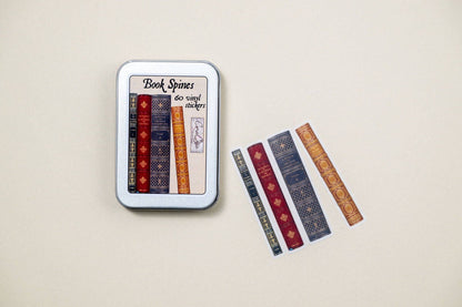 Tin box of book spine stickers with two patterned sticker strips outside