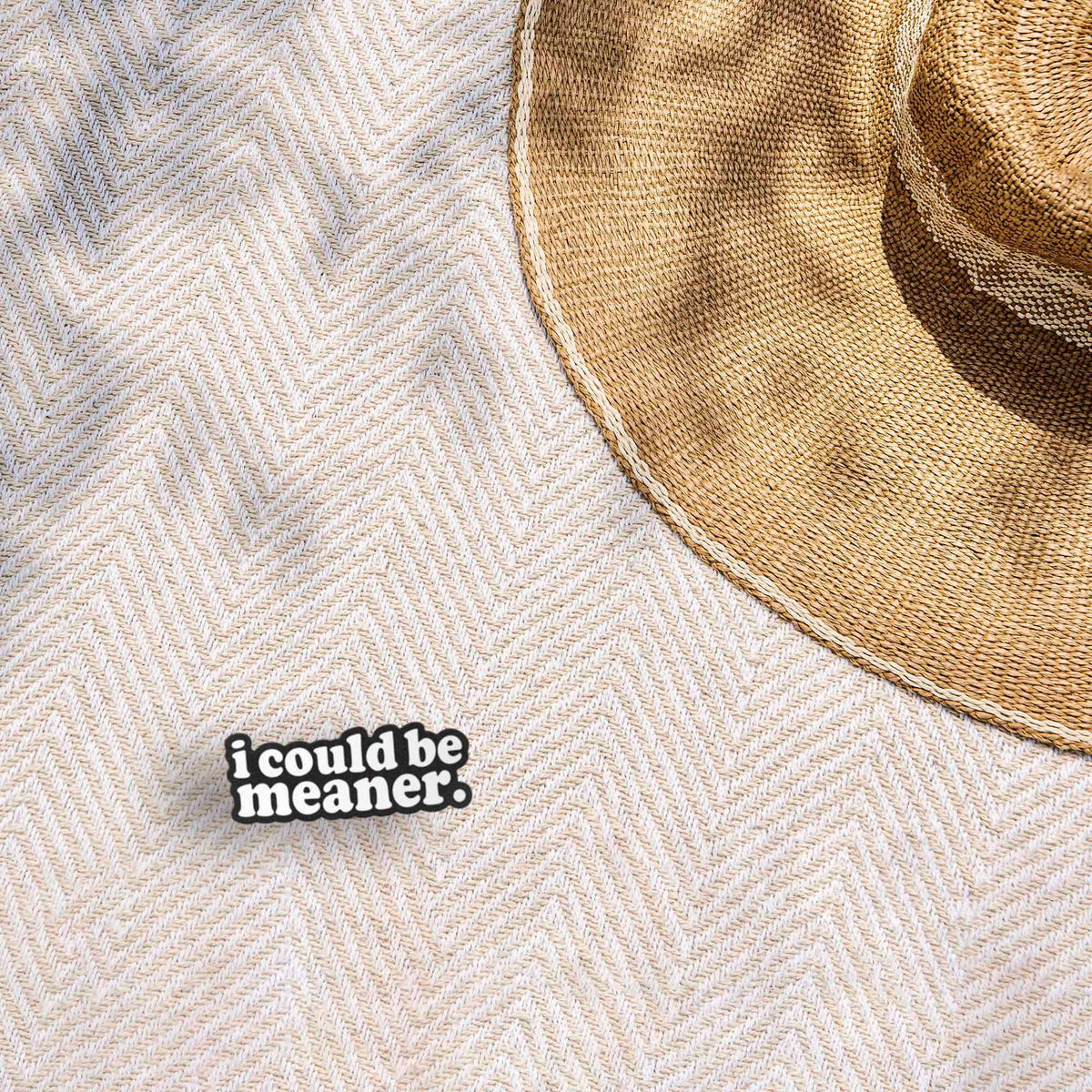 Funny quote sticker reading "i could be meaner." on a beige fabric hat