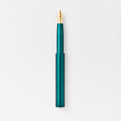 Teal green pocket fountain pen with gold nib, uncapped.