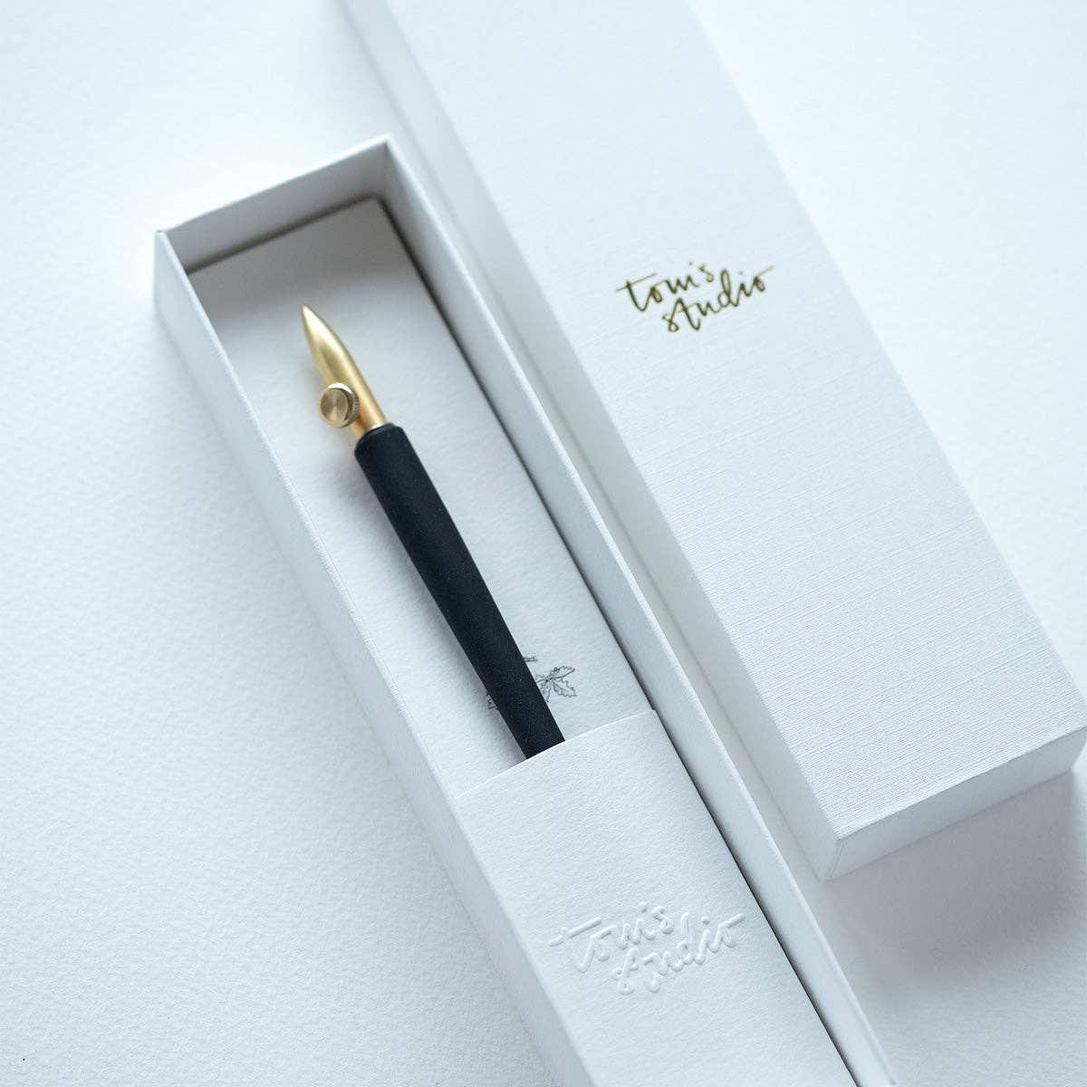 Dip pen with gold nib and black grip in a white gift box