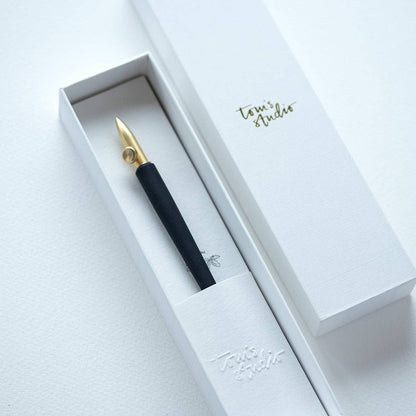 Dip pen with gold nib and black grip in a white gift box
