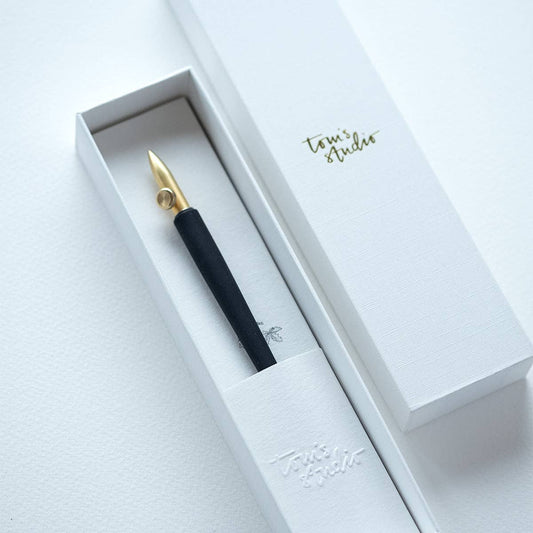 Dip pen with gold nib and black grip in a white gift box