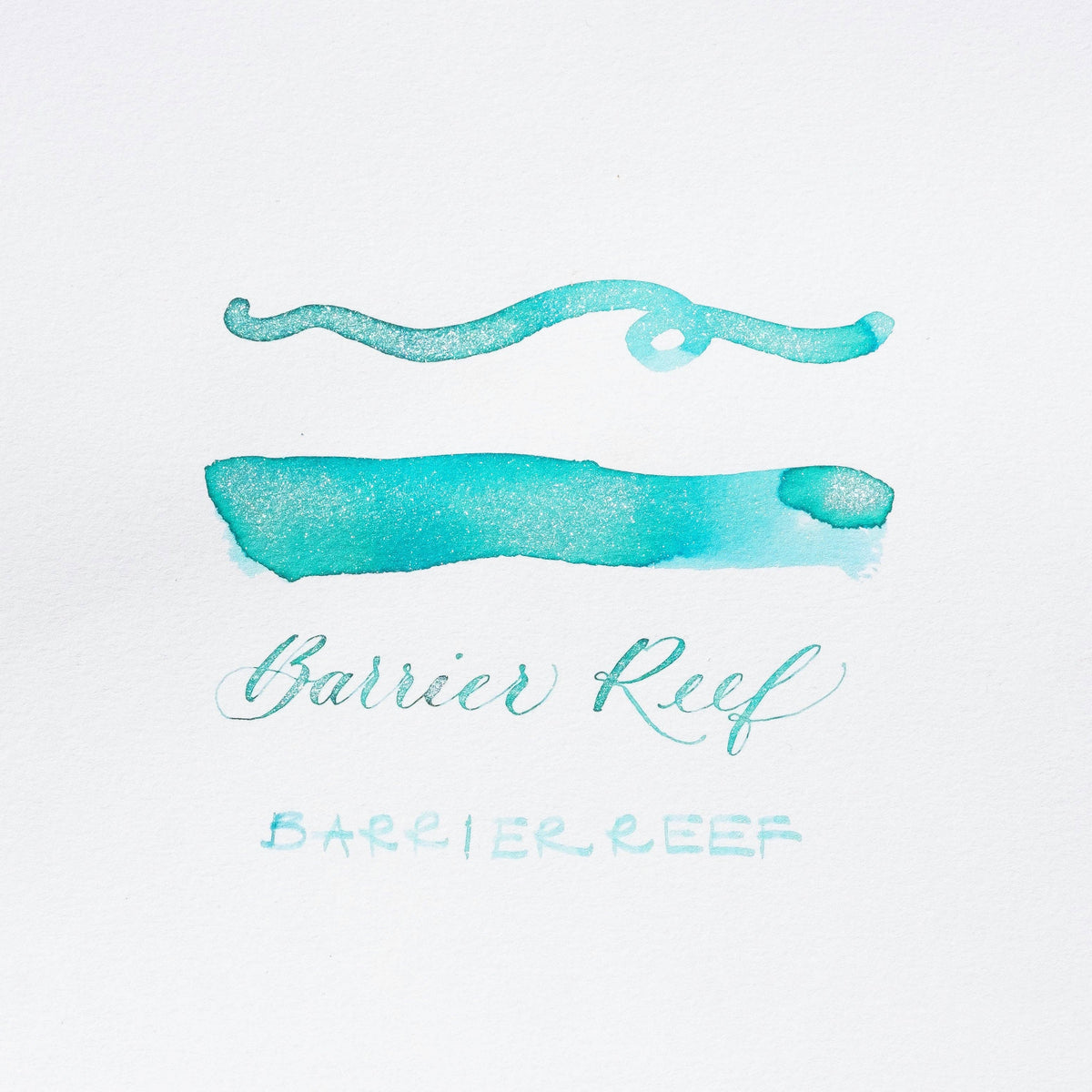 Turquoise shimmer ink brush strokes and “Barrier Reef” script lettering on card