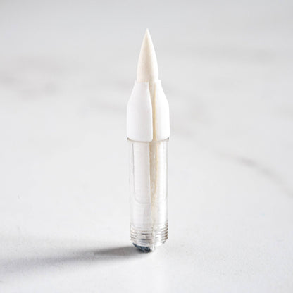 White brush tip pen with fine pointed bristles, no cap visible