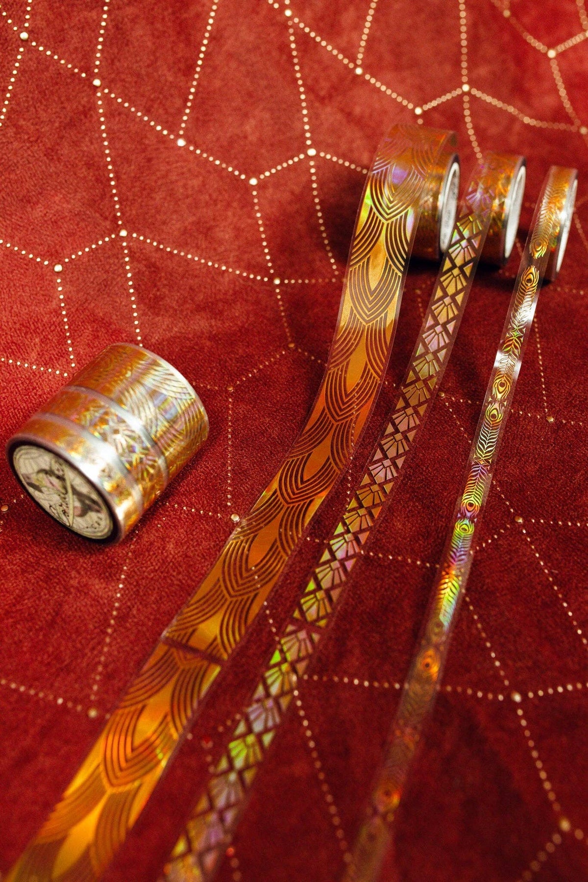 Gold art deco patterned transparent tape rolls with two ribbon strips and a loose roll