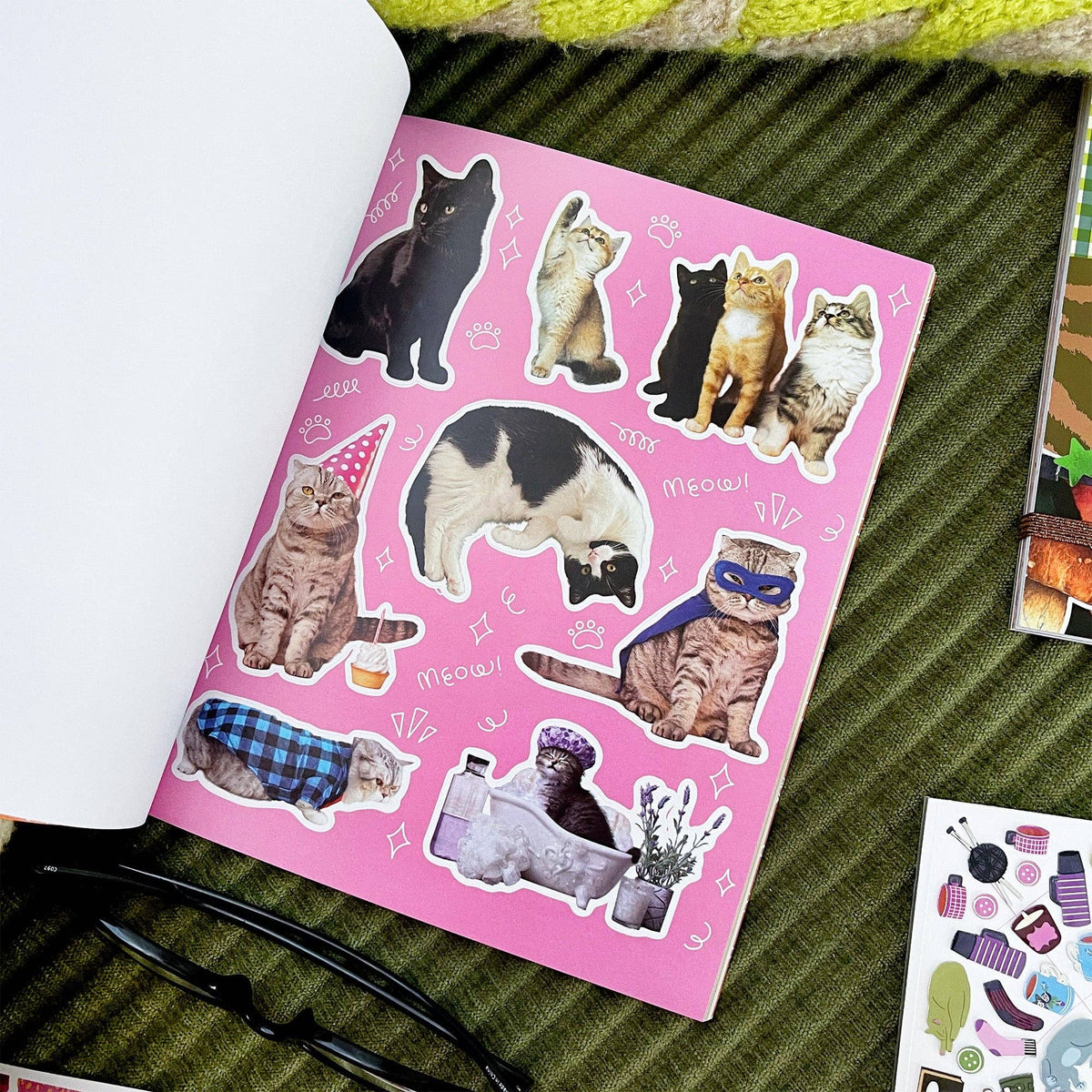 Cat sticker book page with pink background and various cat stickers with paws and hearts