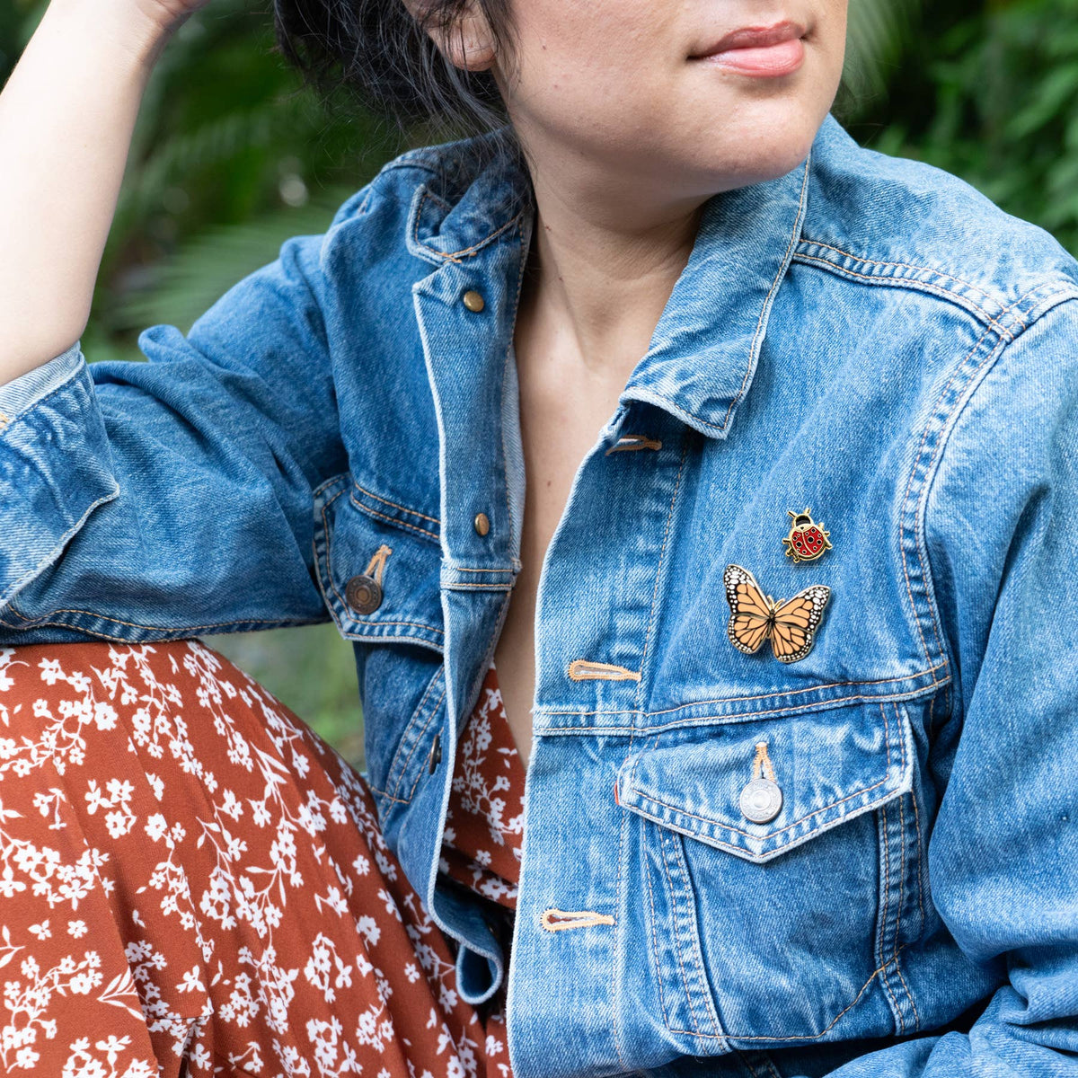 Butterfly pins on a blue denim jacket collar and chest.