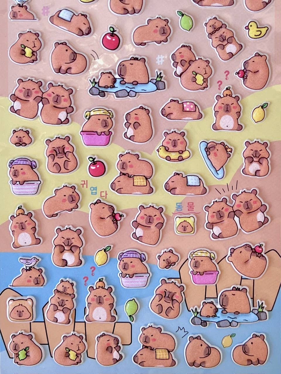 Close-up of cartoon capybara stickers with cherries, hearts, ducks, and treats