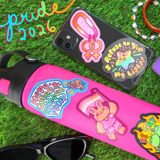 Vinyl sticker on pink tumbler: cat-and-rainbow 'Be Gay Read Books' design
