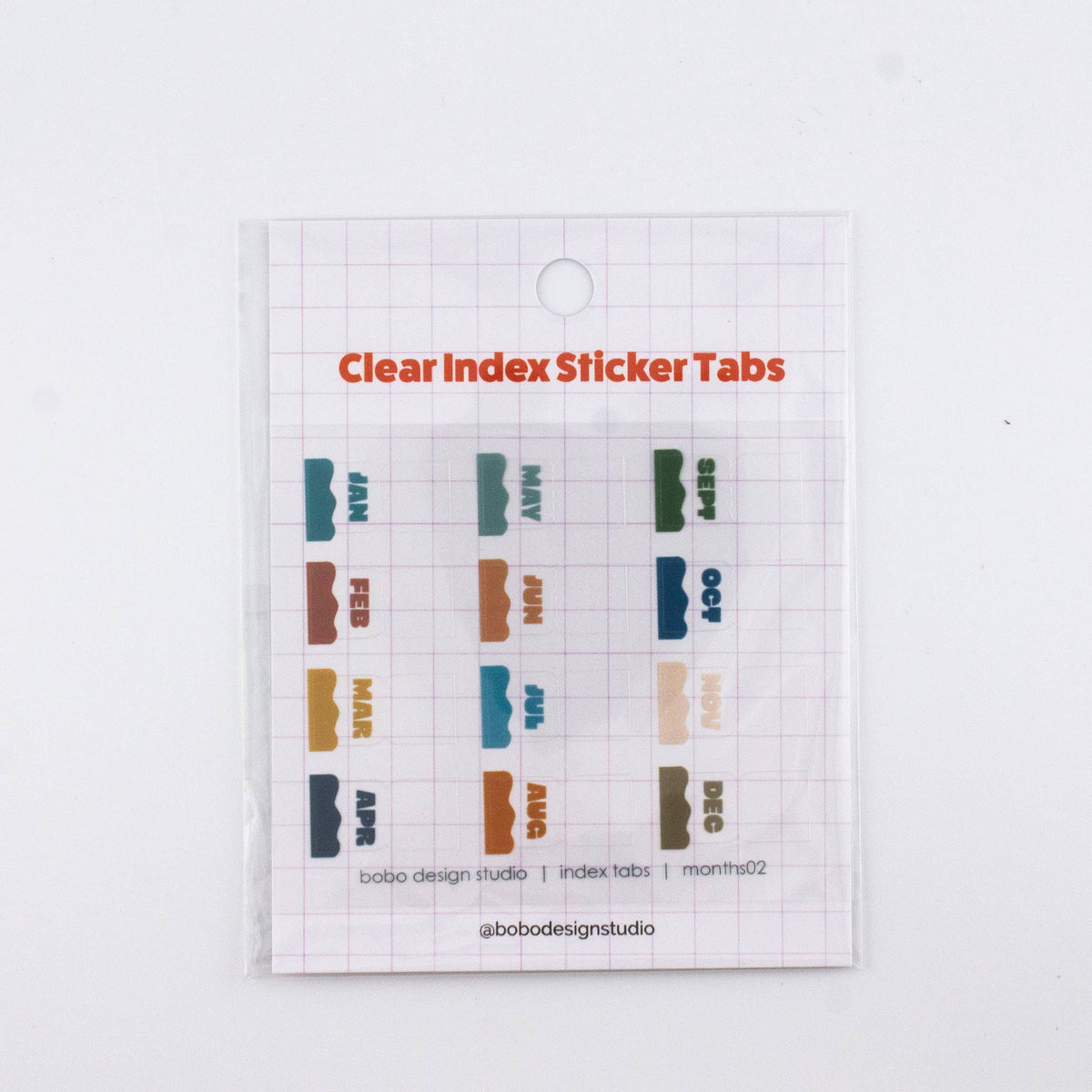 Clear planner index sticker tabs with colorful month labels on a transparent sheet