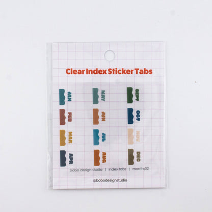 Clear planner index sticker tabs with colorful month labels on a transparent sheet