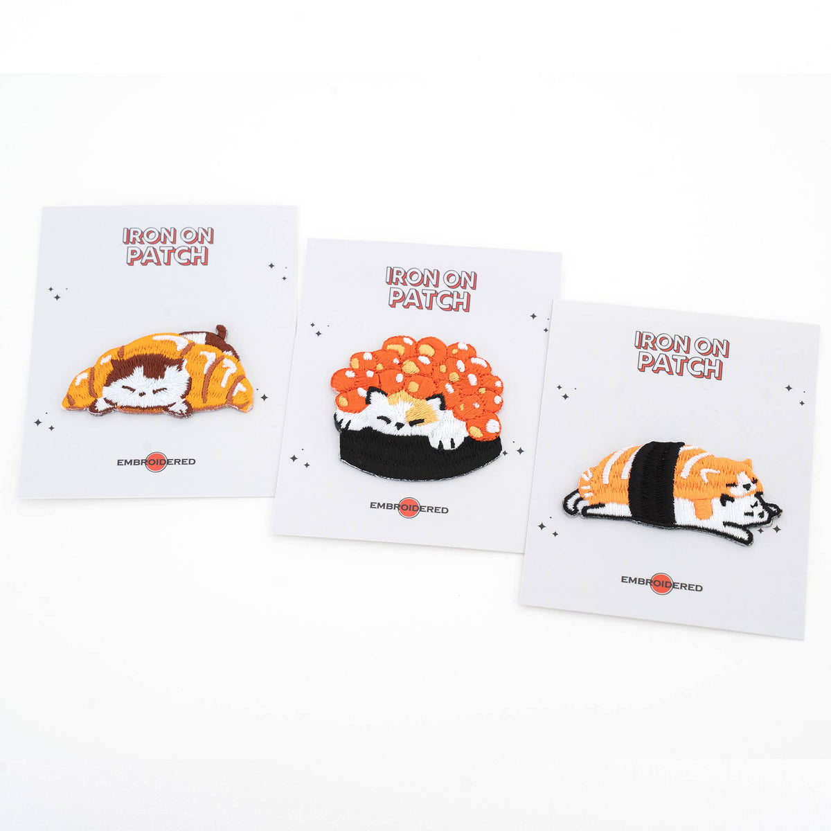 Set of four iron-on cat food patch cards with embroidered designs: croissant, roe, and salmon
