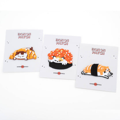Set of four iron-on cat food patch cards with embroidered designs: croissant, roe, and salmon