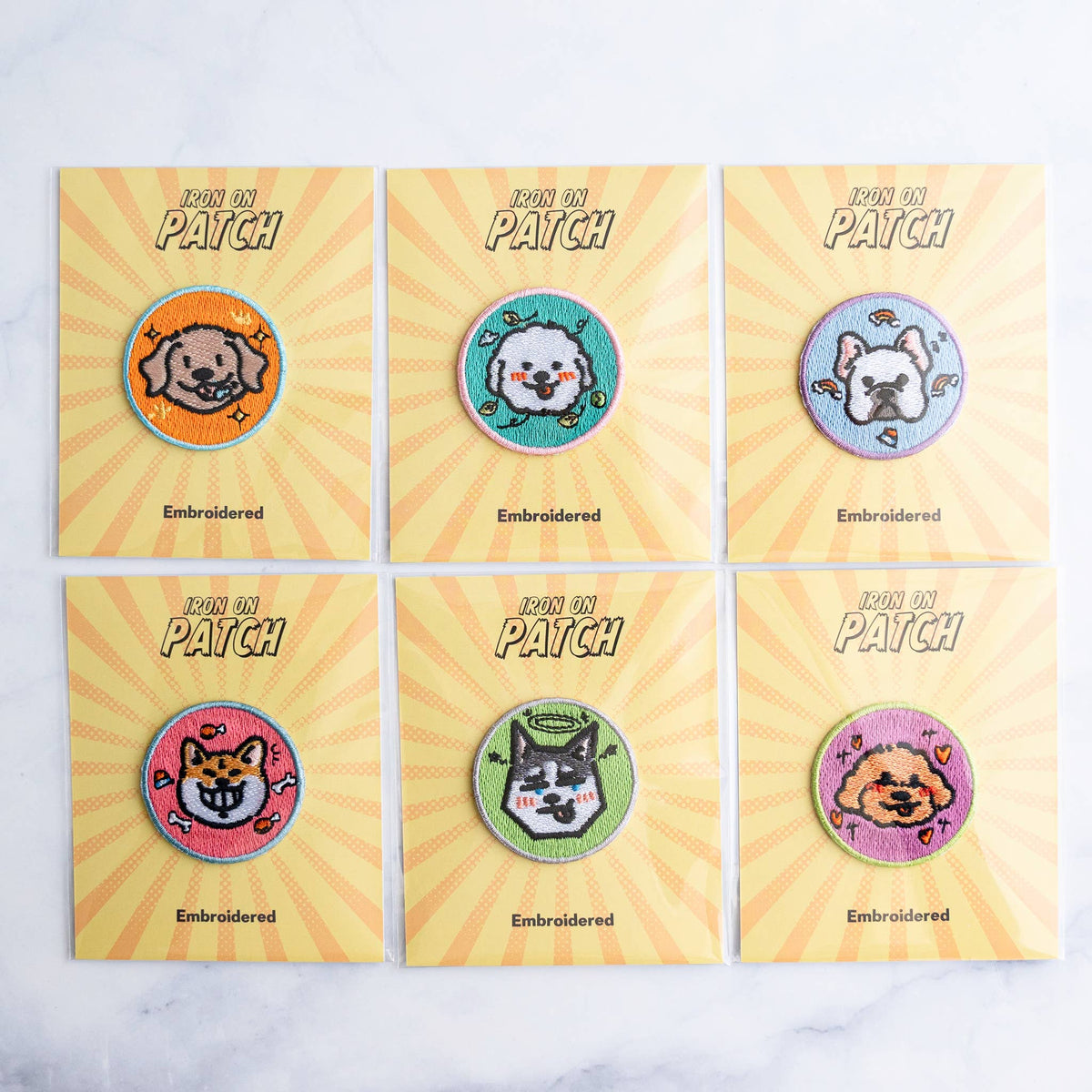 Set of six round embroidered dog iron-on patches with colorful cartoon faces