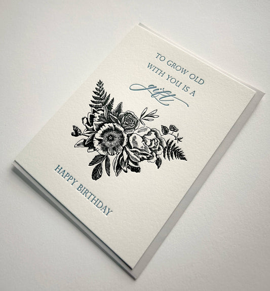 Birthday card with black floral bouquet, cursive “gift” text, and “Happy Birthday”