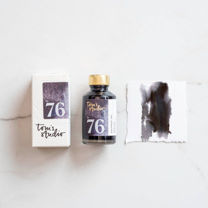 Shimmer ink bottle with metallic purple swatch and ink box, gold cap