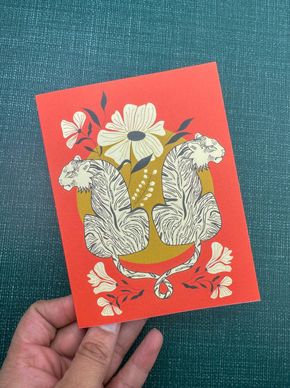 Coral greeting card featuring mirrored tigers, flowers, and foliage