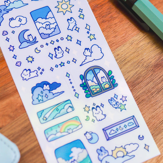 Clear sticker sheet close-up with blue cloudy bunny icons and star shapes