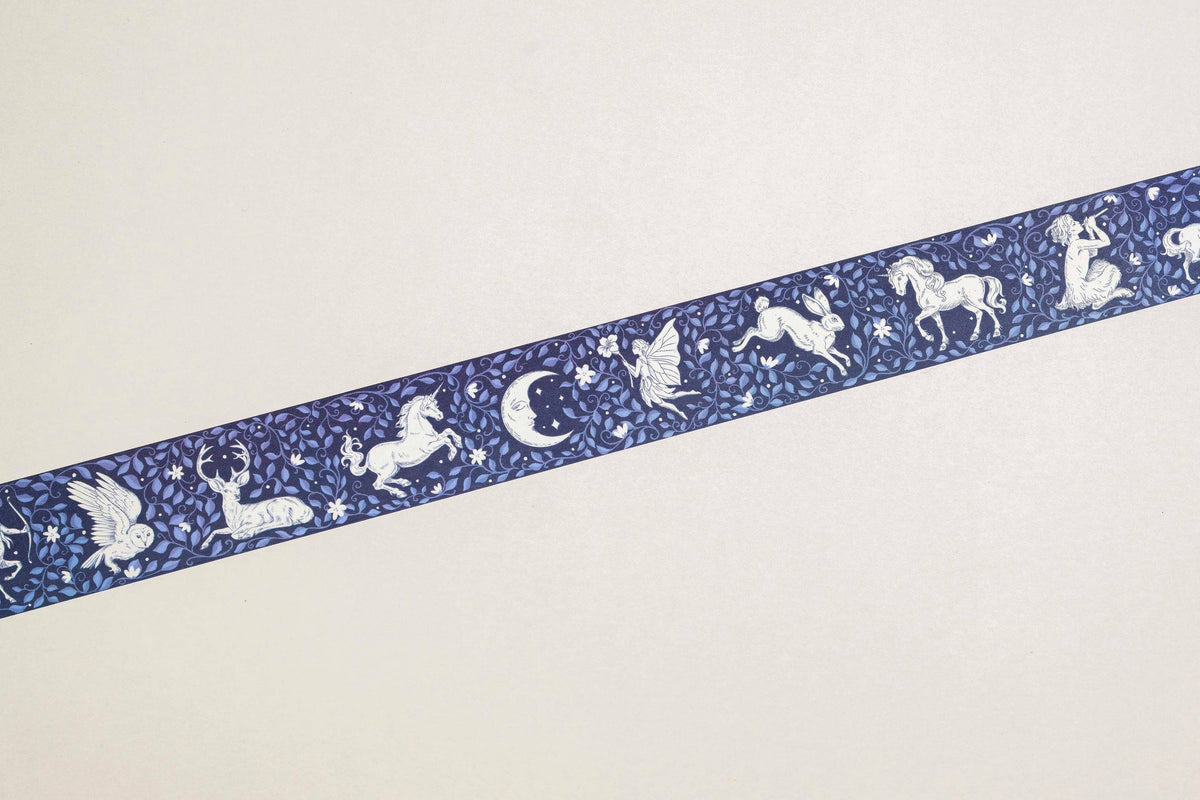Washi tape strip in navy blue with white unicorn, moon, and star motifs
