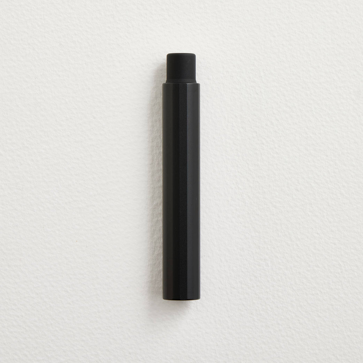 Black pocket fountain pen with cap, upright.