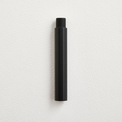 Black pocket fountain pen with cap, upright.
