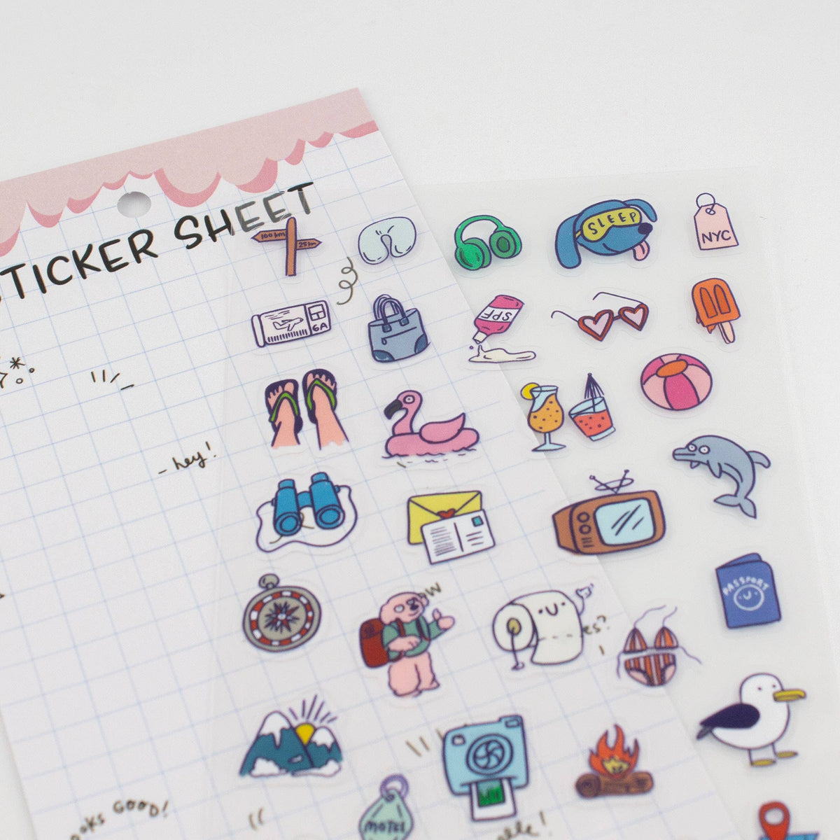 Close-up clear sticker sheet with colorful travel icons like shoes, seal, and postcards